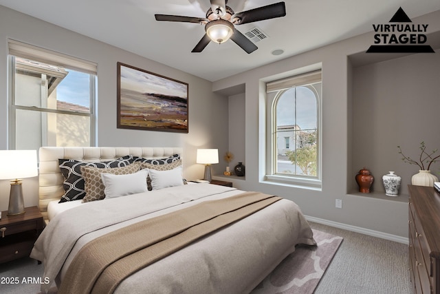 bedroom featuring carpet floors, visible vents, baseboards, and multiple windows