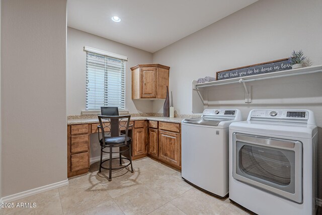 clothes washing area featuring light tile patterned flooring, washing machine and clothes dryer, cabinet space, and baseboards