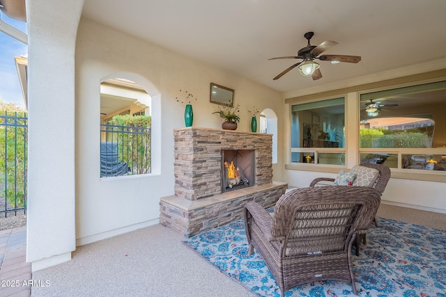 view of patio featuring an outdoor stone fireplace and a ceiling fan