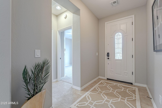 foyer entrance with visible vents, baseboards, and light tile patterned flooring