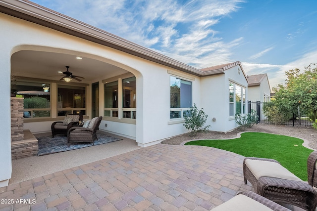 view of patio / terrace with fence and a ceiling fan