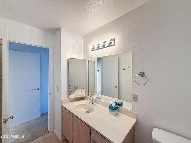 bathroom with vanity, a textured ceiling, and toilet