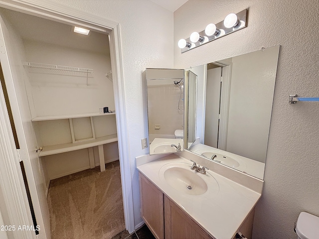 bathroom with vanity, toilet, and a shower