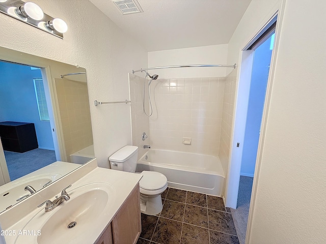 full bathroom featuring vanity, tile patterned flooring, tiled shower / bath combo, and toilet