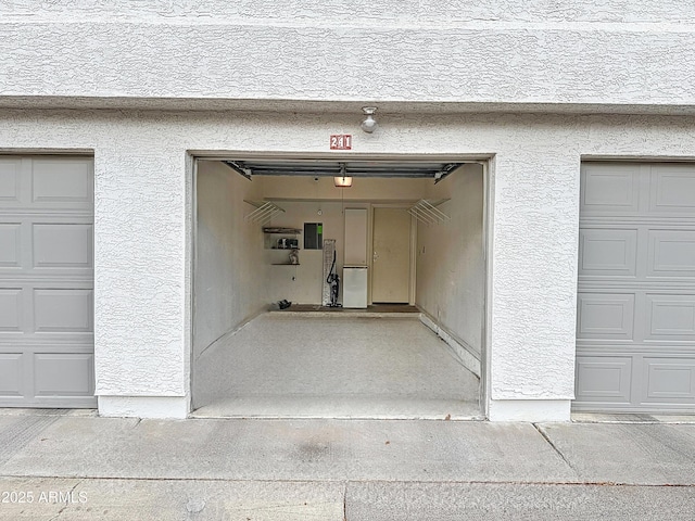 garage with a garage door opener and electric panel