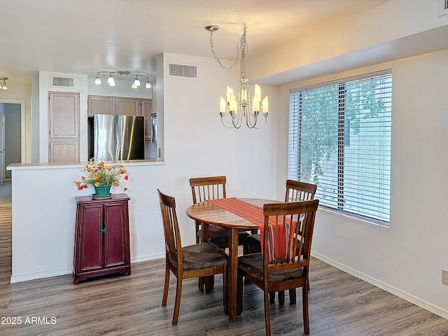 dining space featuring a notable chandelier and dark wood-type flooring