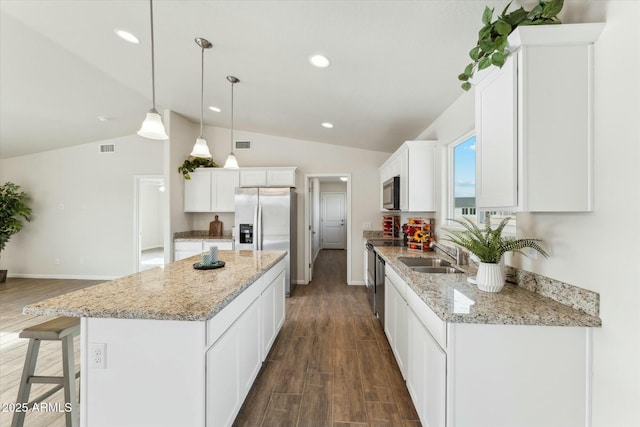 kitchen featuring a center island, dark wood finished floors, lofted ceiling, a sink, and stainless steel fridge