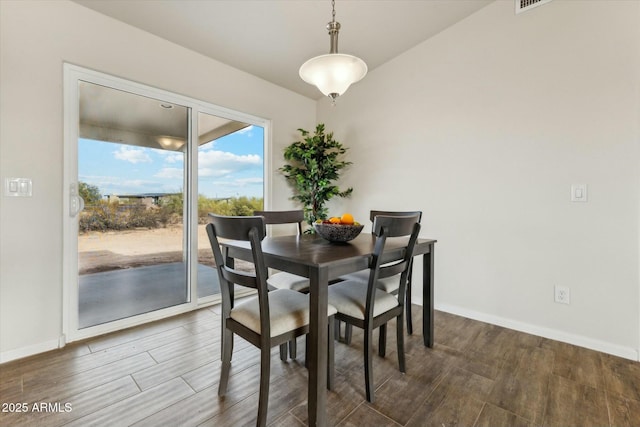 dining area with baseboards and wood finished floors