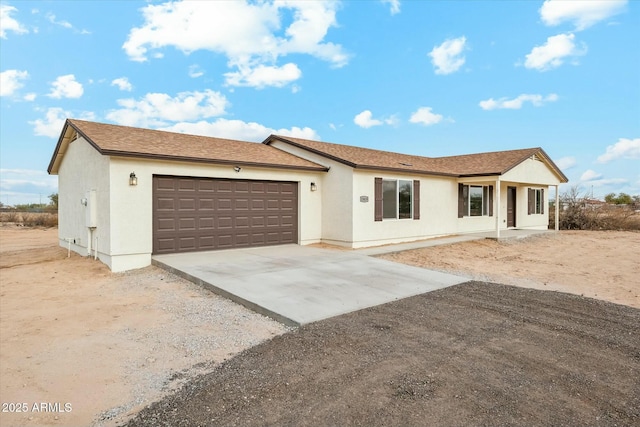 single story home featuring a garage, driveway, roof with shingles, and stucco siding