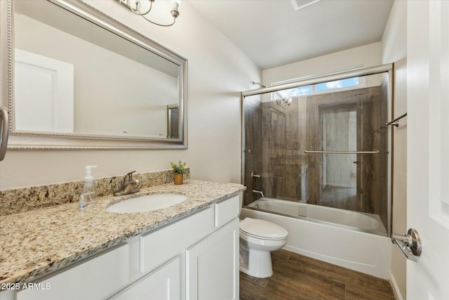 bathroom featuring vanity, combined bath / shower with glass door, wood finished floors, and toilet