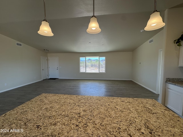 unfurnished living room with dark wood-type flooring, lofted ceiling, visible vents, and baseboards