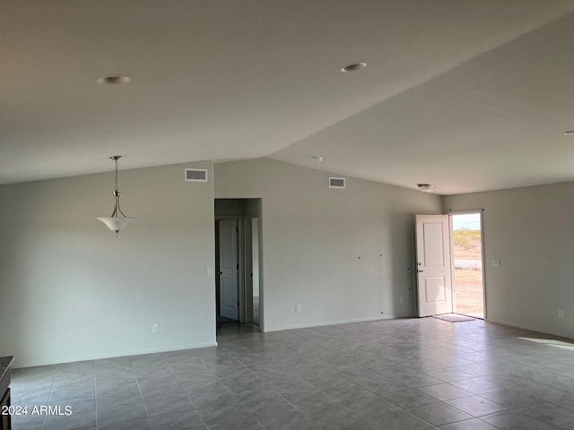 unfurnished room with lofted ceiling, visible vents, and baseboards