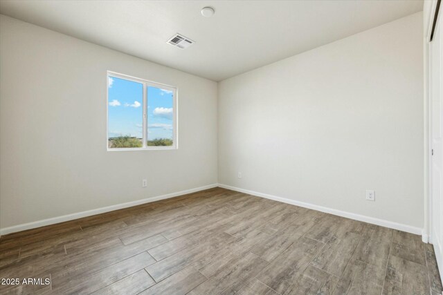 hall featuring visible vents, baseboards, dark wood-type flooring, and a textured ceiling