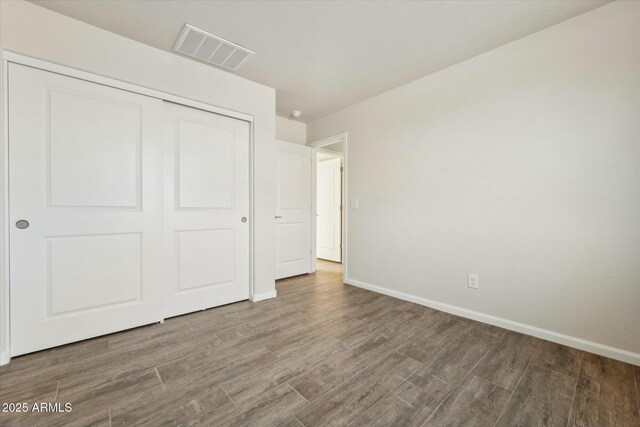 full bath with a stall shower, wood finish floors, a sink, and double vanity