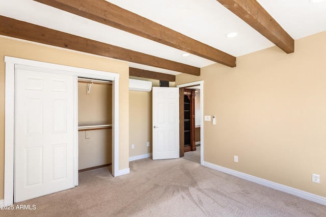 unfurnished bedroom with a wall unit AC, light colored carpet, baseboards, a closet, and beam ceiling