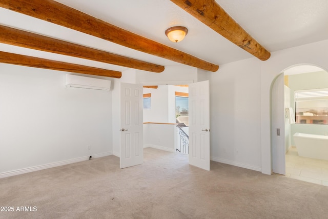 carpeted spare room featuring arched walkways, beam ceiling, baseboards, and a wall mounted AC