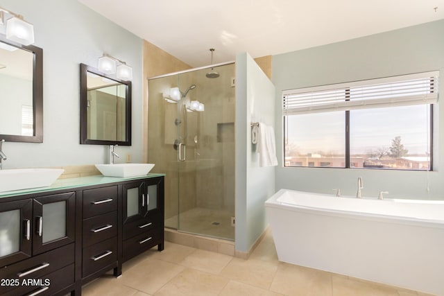 bathroom with a stall shower, a sink, and a freestanding bath