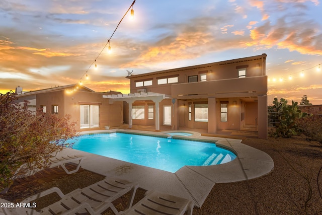 pool at dusk featuring an in ground hot tub, a patio, a pergola, and an outdoor pool