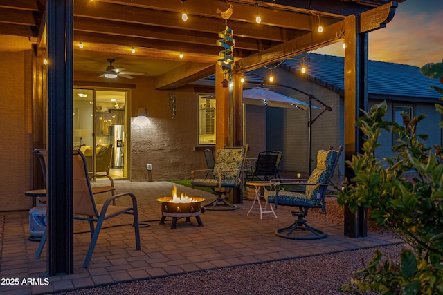 view of patio / terrace featuring ceiling fan and a fire pit