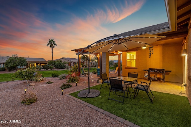 yard at dusk featuring a patio area