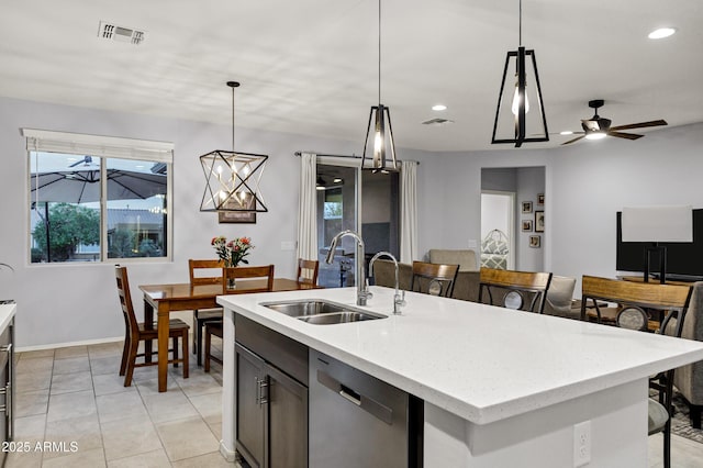 kitchen featuring a sink, visible vents, pendant lighting, and dishwasher