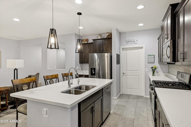 kitchen with decorative backsplash, a breakfast bar, hanging light fixtures, stainless steel appliances, and a sink