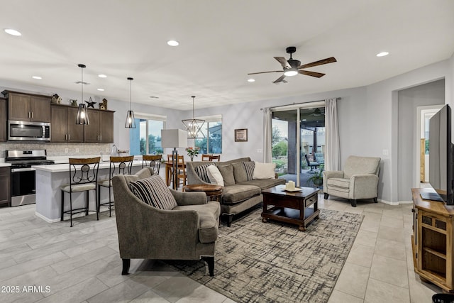 living area with a ceiling fan, recessed lighting, and baseboards