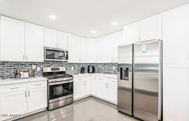 11215 N 37th Ave, Phoenix, AZ 85029 - kitchen featuring appliances with stainless steel finishes, light countertops, tasteful backsplash, white cabinetry, and recessed lighting