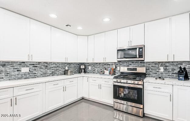 11215 N 37th Ave, Phoenix, AZ 85029 - kitchen featuring appliances with stainless steel finishes, light countertops, decorative backsplash, white cabinetry, and recessed lighting