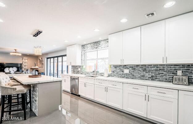 11215 N 37th Ave, Phoenix, AZ 85029 - kitchen with dishwasher, a sink, light countertops, decorative backsplash, and white cabinetry