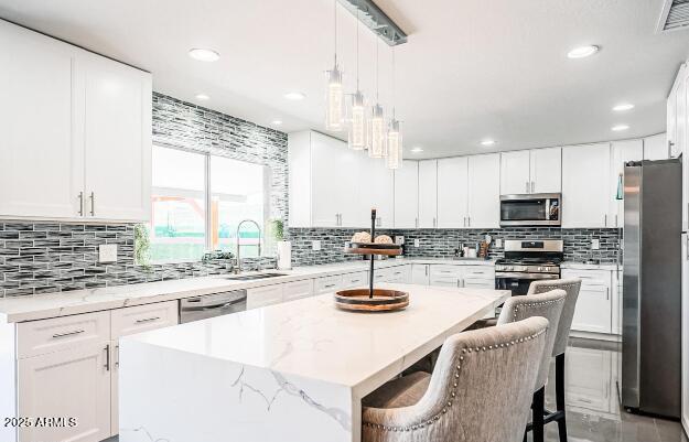 11215 N 37th Ave, Phoenix, AZ 85029 - kitchen featuring appliances with stainless steel finishes, a kitchen island, a sink, tasteful backsplash, and recessed lighting