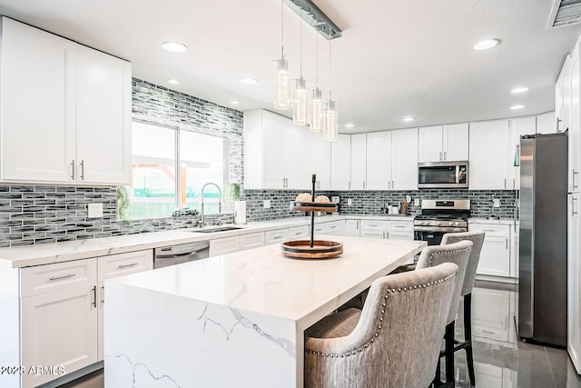 11215 N 37th Ave, Phoenix, AZ 85029 - kitchen with appliances with stainless steel finishes, a sink, a kitchen island, backsplash, and white cabinets