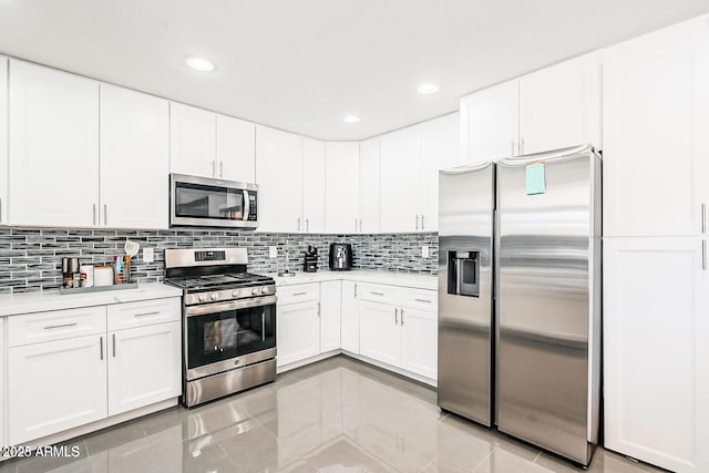 11215 N 37th Ave, Phoenix, AZ 85029 - kitchen featuring stainless steel appliances, light countertops, decorative backsplash, white cabinets, and light tile patterned floors