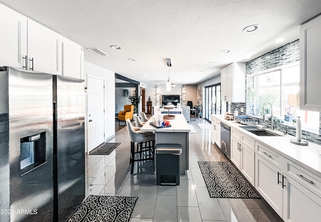 11215 N 37th Ave, Phoenix, AZ 85029 - kitchen featuring appliances with stainless steel finishes, a sink, a kitchen bar, dark tile patterned floors, and light countertops