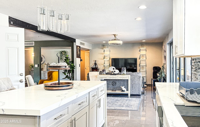 11215 N 37th Ave, Phoenix, AZ 85029 - kitchen with white cabinetry, light stone counters, open floor plan, hanging light fixtures, and recessed lighting