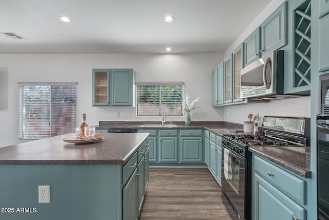 kitchen featuring a center island, sink, black range with gas stovetop, and dark hardwood / wood-style floors