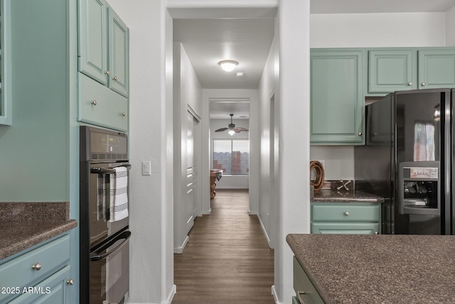 kitchen featuring dark wood-type flooring, ceiling fan, and black appliances