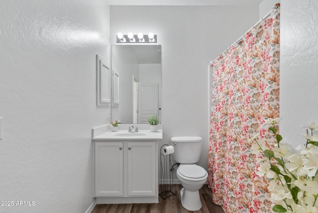 bathroom with vanity, wood-type flooring, and toilet