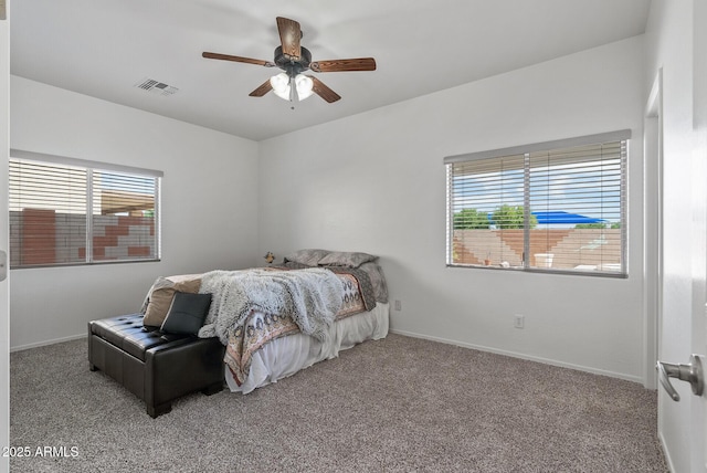 carpeted bedroom with ceiling fan and multiple windows