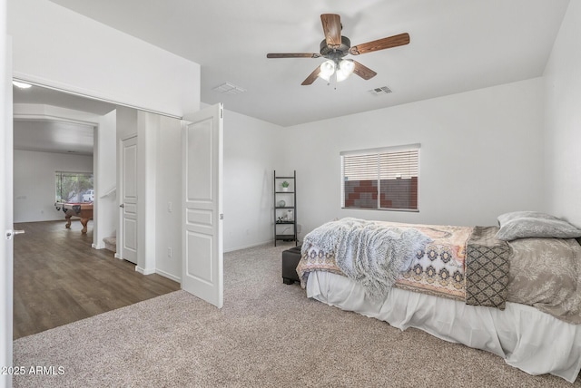 carpeted bedroom featuring multiple windows and ceiling fan