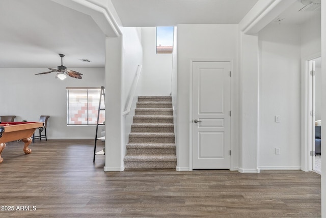 stairs with wood-type flooring and ceiling fan