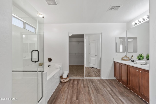 bathroom featuring vanity, plus walk in shower, and hardwood / wood-style floors