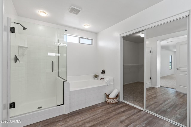 bathroom featuring wood-type flooring and independent shower and bath