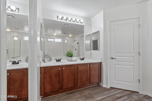 bathroom featuring walk in shower, vanity, and hardwood / wood-style floors