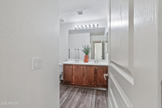 bathroom featuring vanity, hardwood / wood-style floors, and a textured ceiling