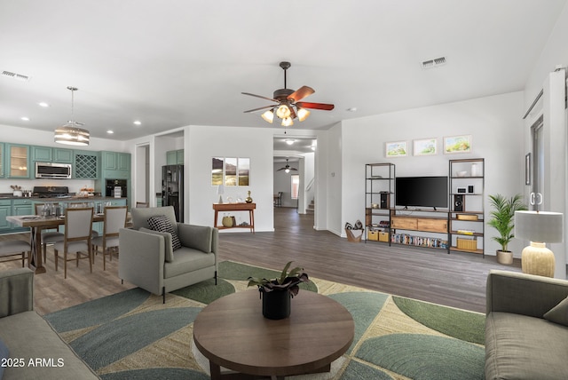 living room with ceiling fan and wood-type flooring