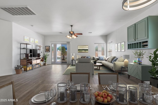 living room with plenty of natural light, dark wood-type flooring, and ceiling fan