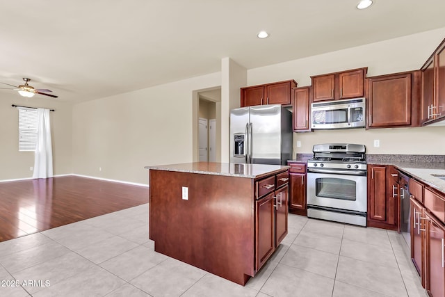 121 W Hackberry Dr, Chandler, AZ 85248 - kitchen featuring appliances with stainless steel finishes, ceiling fan, a kitchen island, light tile patterned floors, and open floor plan