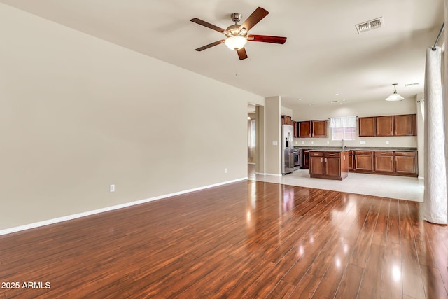 121 W Hackberry Dr, Chandler, AZ 85248 - unfurnished living room featuring wood finished floors, ceiling fan, baseboards, and a sink