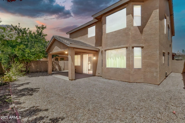121 W Hackberry Dr, Chandler, AZ 85248 - back of property at dusk with stucco siding, a patio area, and a fenced backyard